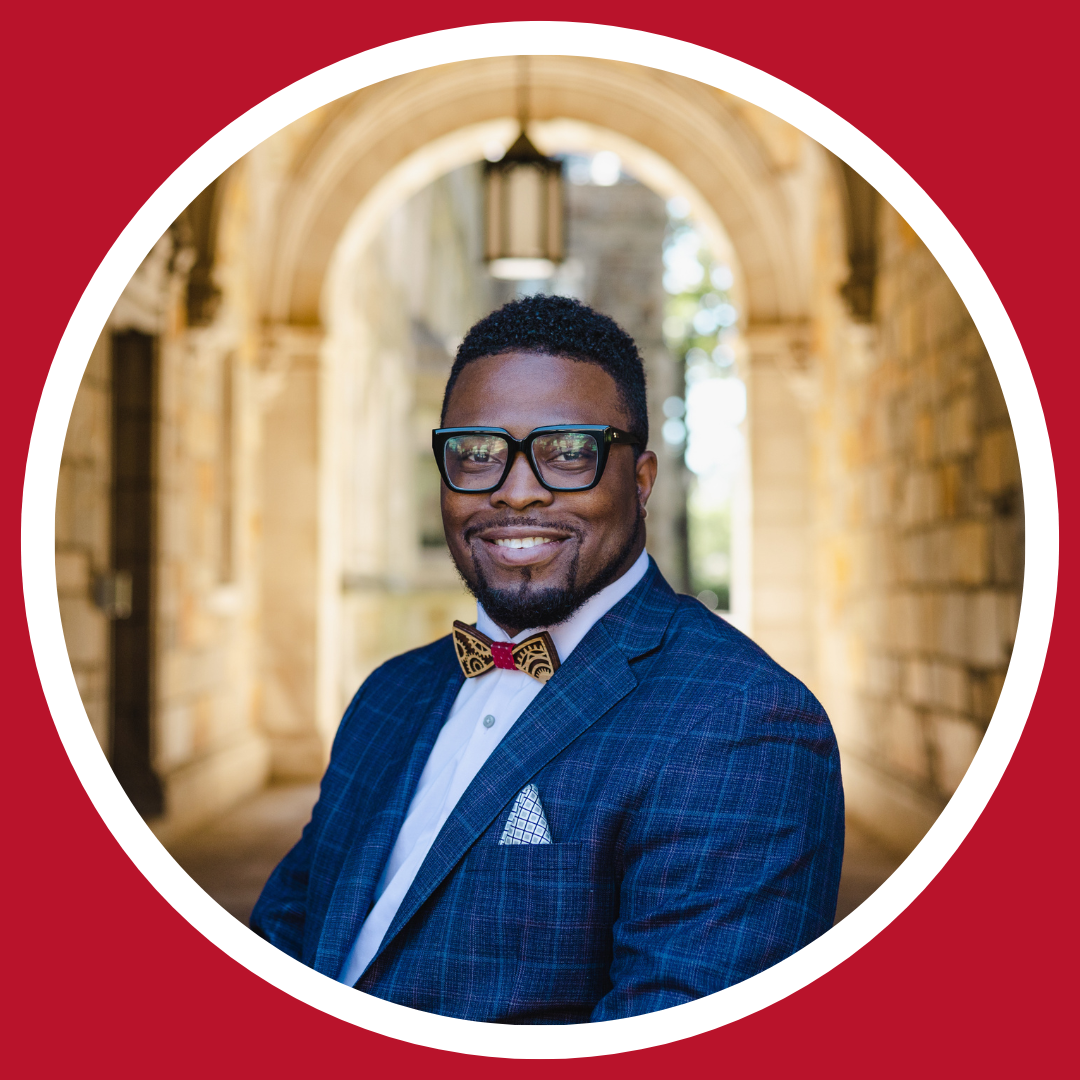 Headshot of Dr. Oluwaferanmi Okanlami. Dr. Okanlami has dark hair and is wearing dark, thick-rimmed glasses. Dr. Okanlami is smiling in the photo.